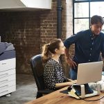 Un homme et une femme se tiennent côte à côte devant un ordinateur, concentrés sur l'écran. L'imprimante couleur Xerox® VersaLink® C7000 est en arrière-plan. Un homme et une femme se tiennent côte à côte devant un ordinateur, concentrés sur l'écran. L'imprimante couleur Xerox® VersaLink® C7000 est en arrière-plan.